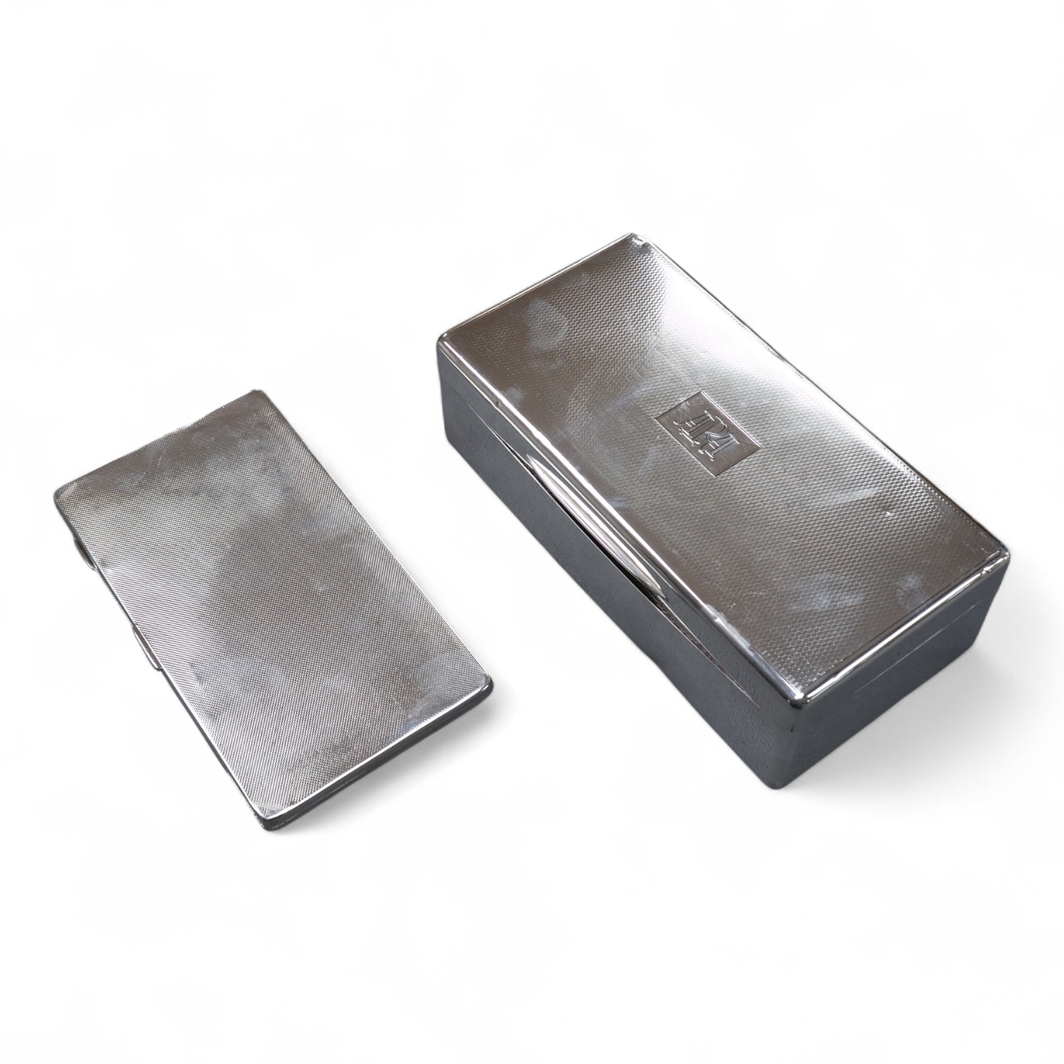 A George V engine turned silver mounted cigarette box, London, 1934, 17.6cm, together with a similar engine turned silver cigarette case.